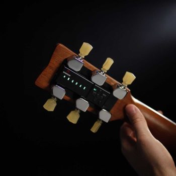 Automatic Guitar Tuner TronicalTune 3+3 Style Hand holding an acoustic guitar neck with a TronicalTune automatic guitar tuner and three motorized tuning pegs per side