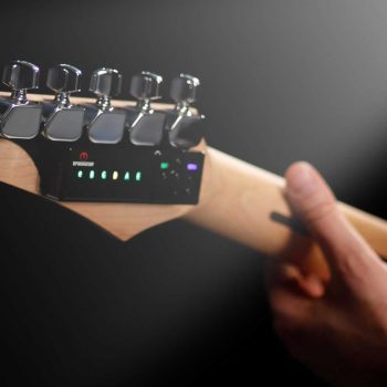 Automatic Guitar Tuner TronicalTune 6-Line Style Hand holding an electric guitar neck with a TronicalTune automatic guitar tuner and six chrome tuning pegs in a row