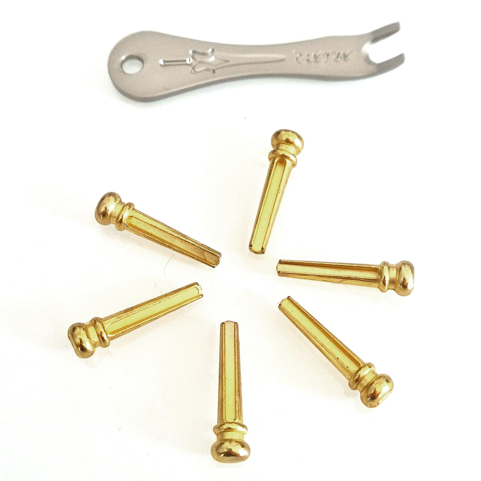 Gold acoustic guitar bridge pins with removal tool Six gold-colored acoustic guitar bridge pins with a metal bridge pin removal tool